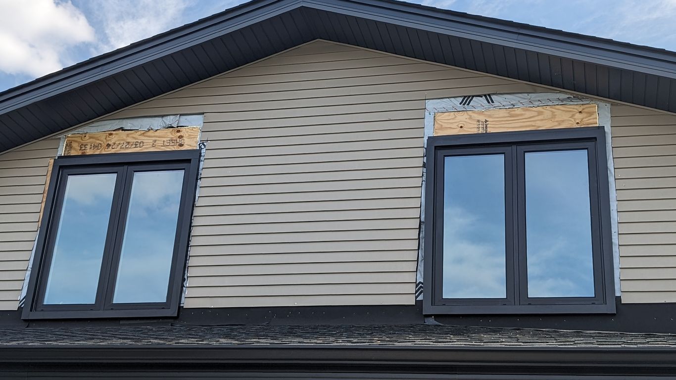 Two new windows installed on a house under construction.