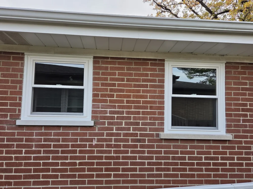 Two white-framed windows in a brick wall on Habberton Street in Park Ridge