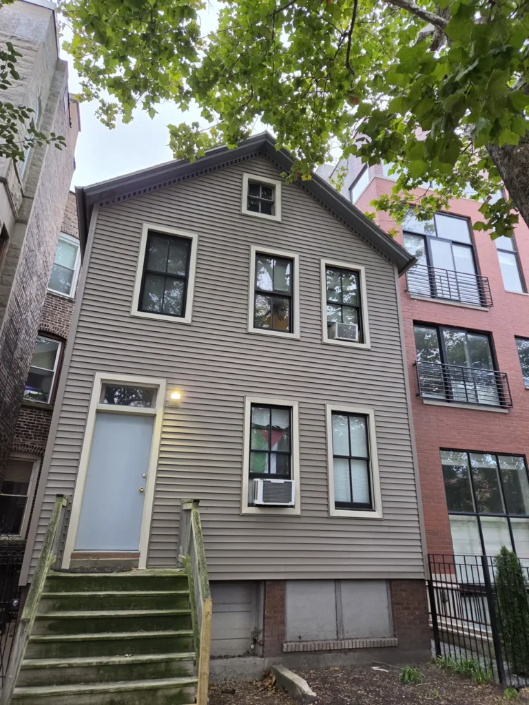 Front exterior with new horizontal siding on Huron Street in Chicago
